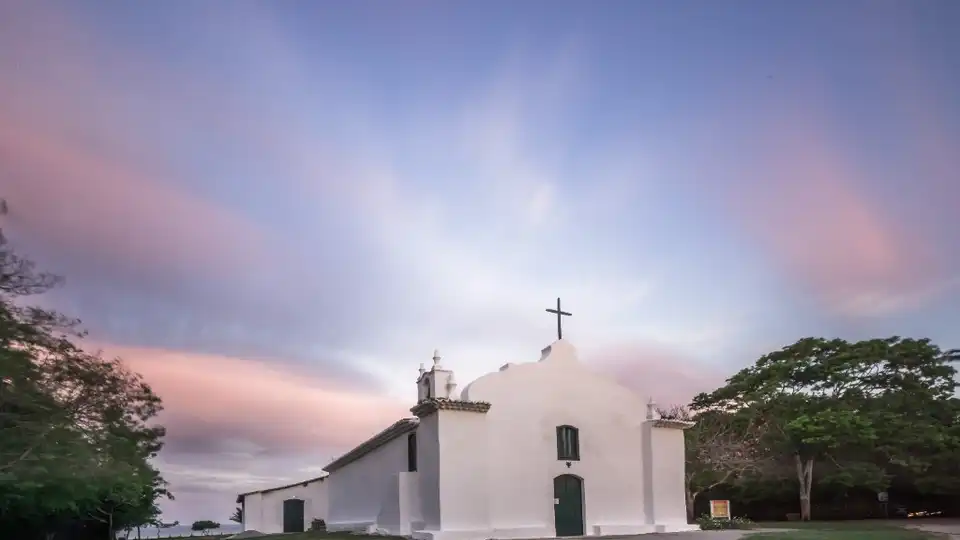 Igreja de São João Batista no Quadrado de Trancoso, BA, durante pôr do sol com céu rosado