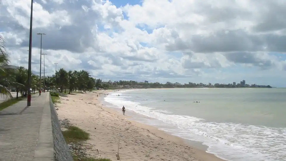 Praia de Manaíra em João Pessoa, PB — calçadão, coqueiros e orla curva com mar calmo ao fundo